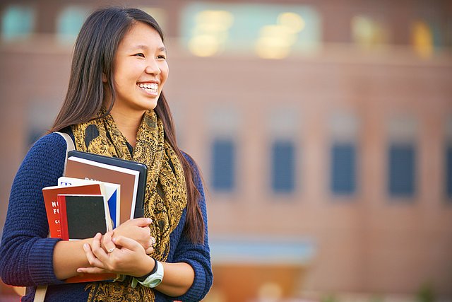 A young woman holding books.