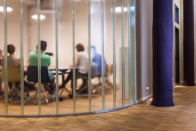 A meeting a taking place at a uni-assist conference room.